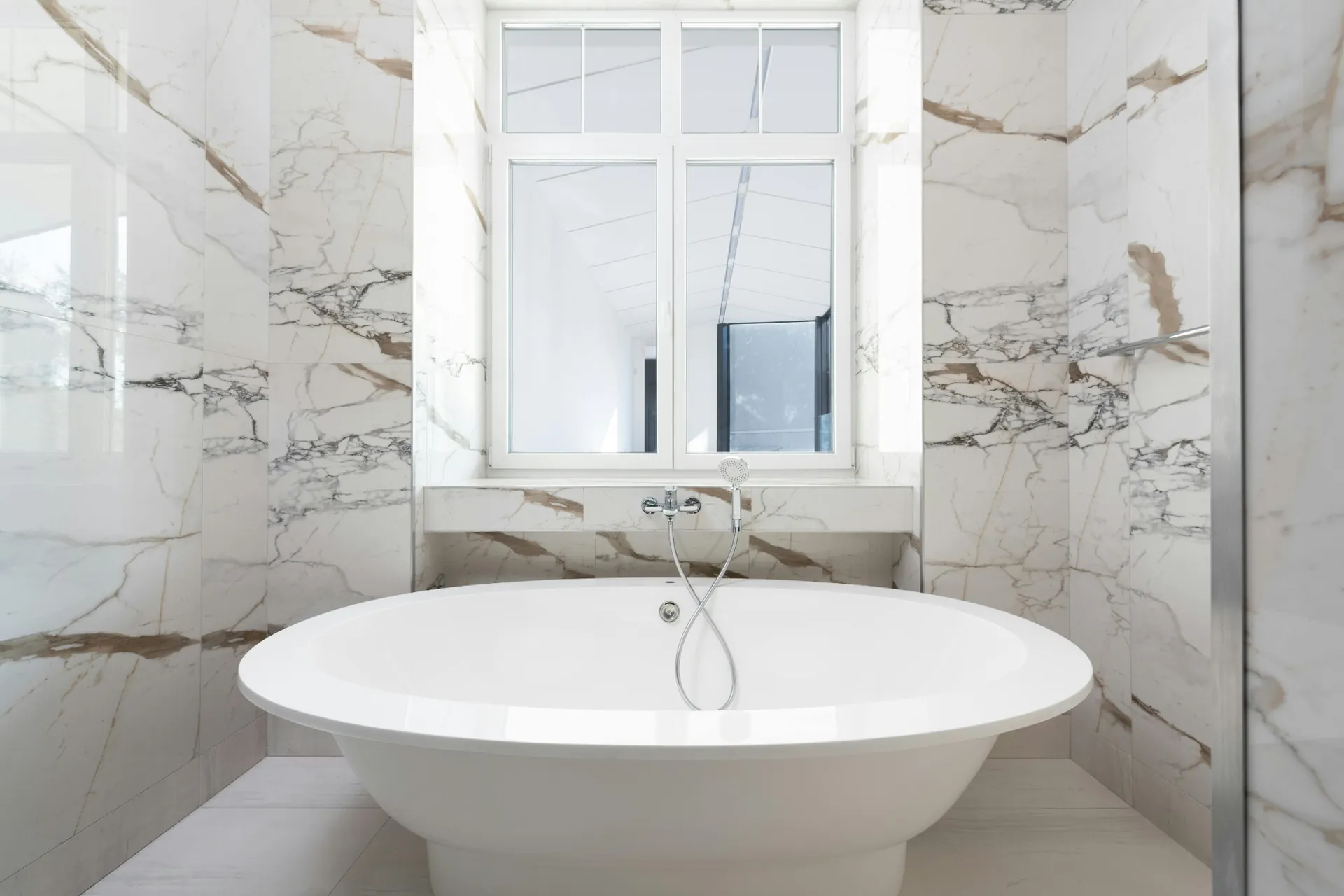 Freestanding tub surrounded by marble-look Caesarstone walls in a Vancouver bathroom