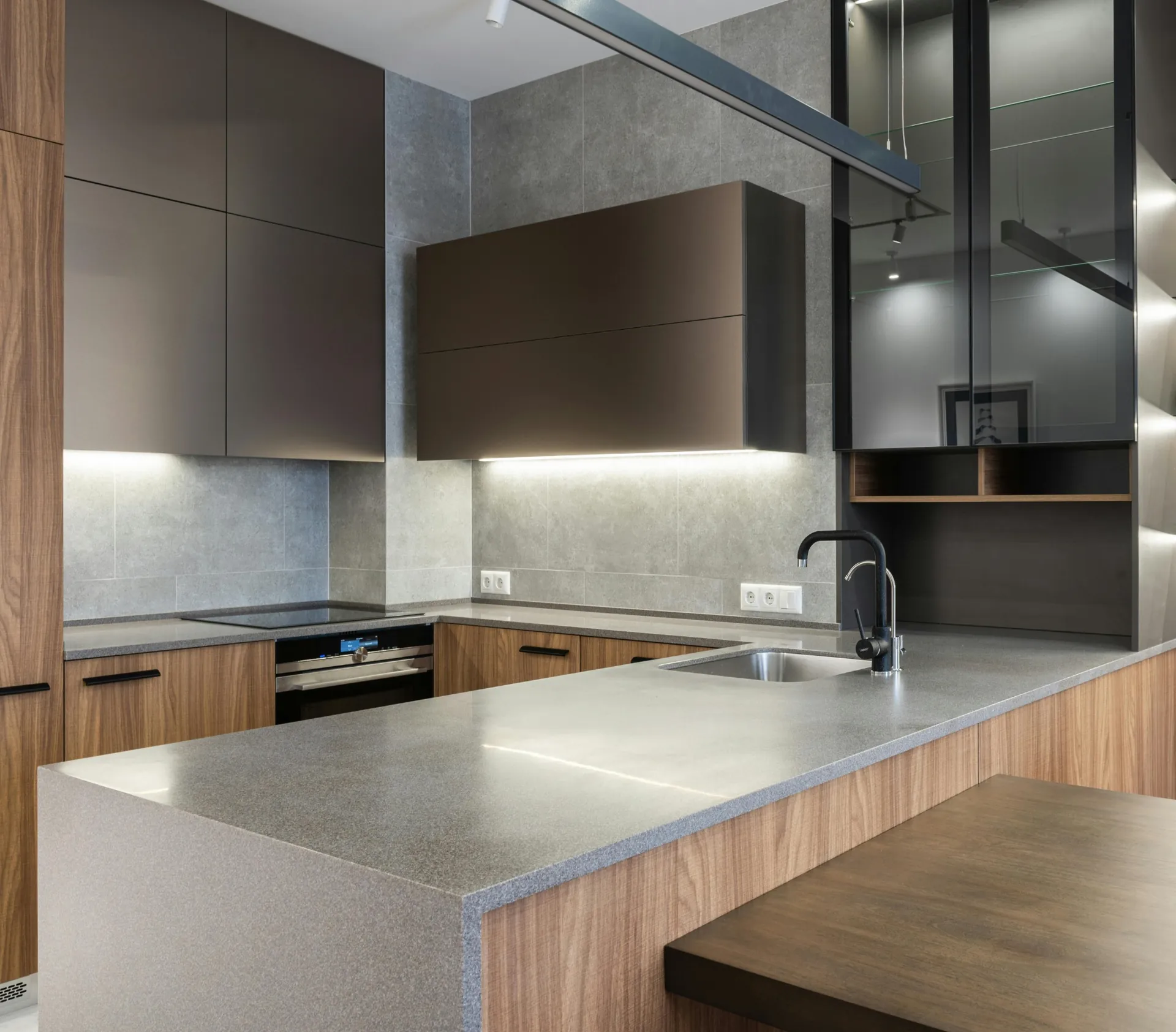 Contemporary kitchen with grey quartz peninsula and wood cabinetry