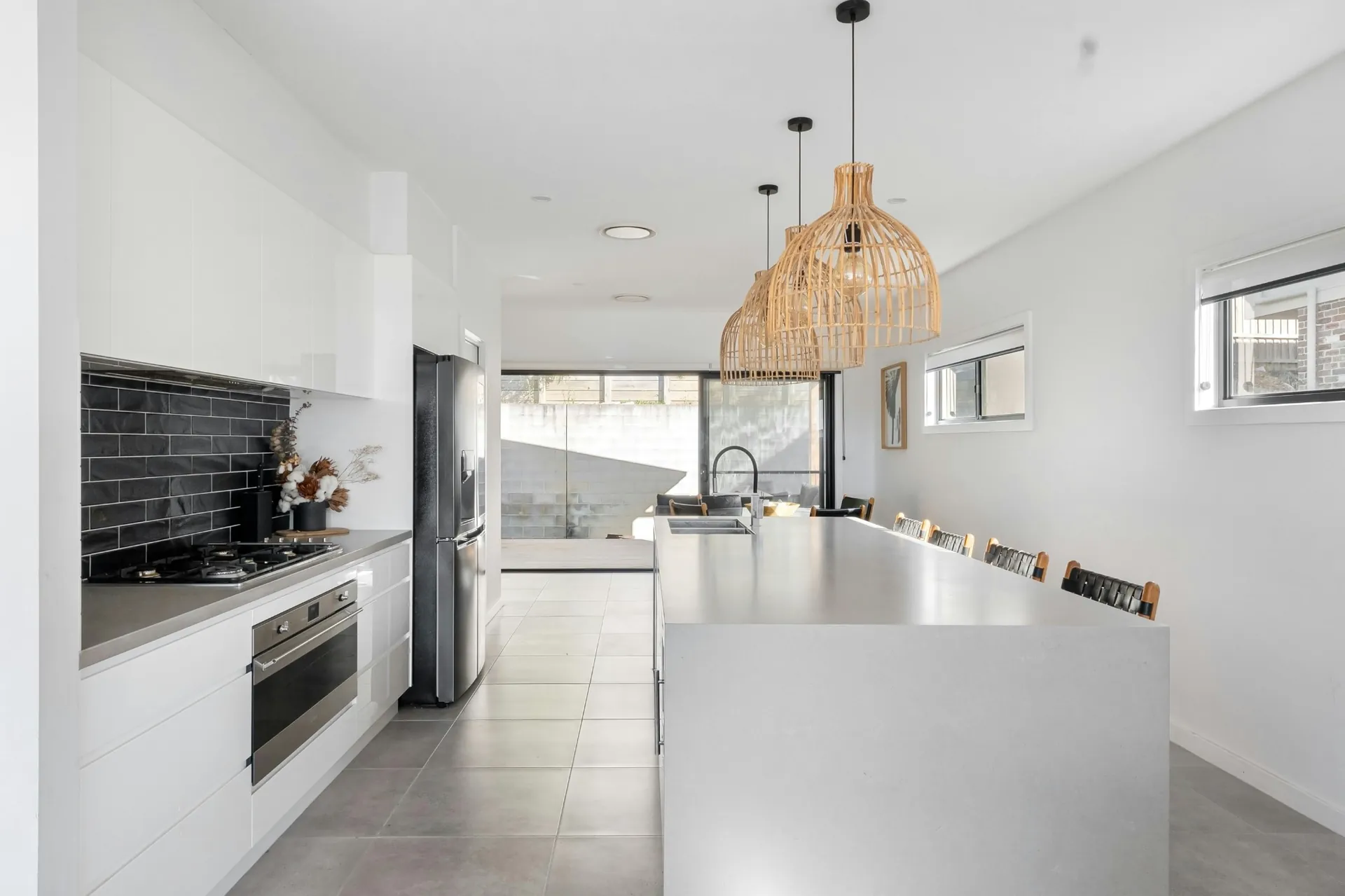 Modern white kitchen with long Cambria quartz island and black accents