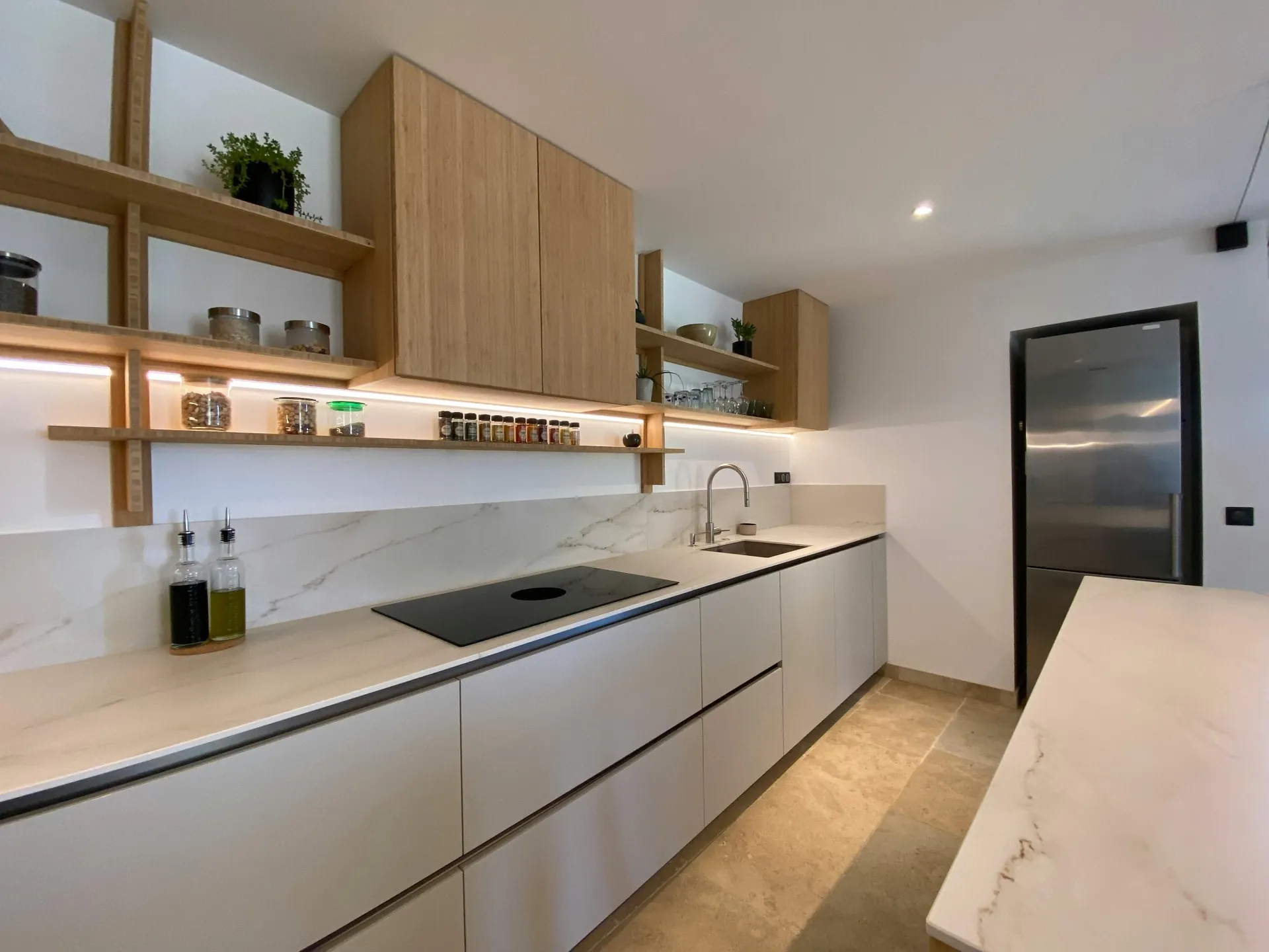 Warm marble-look quartz used on backsplash and countertops in a kitchen