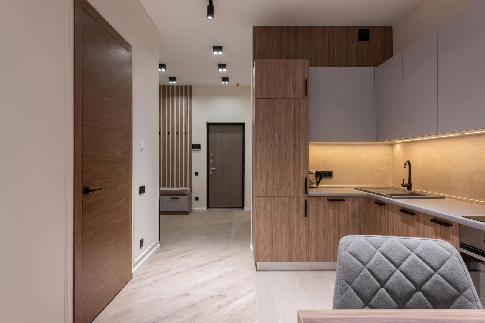 Warm wood kitchen with Dekton-style counters and under-cabinet lighting