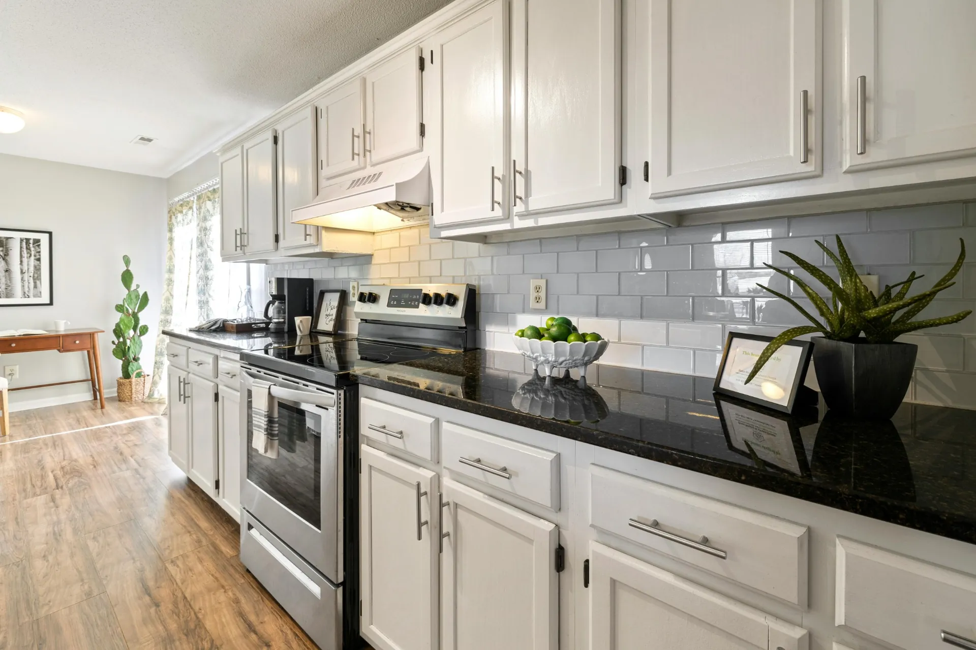 Transitional kitchen with black quartz countertops and white cabinets
