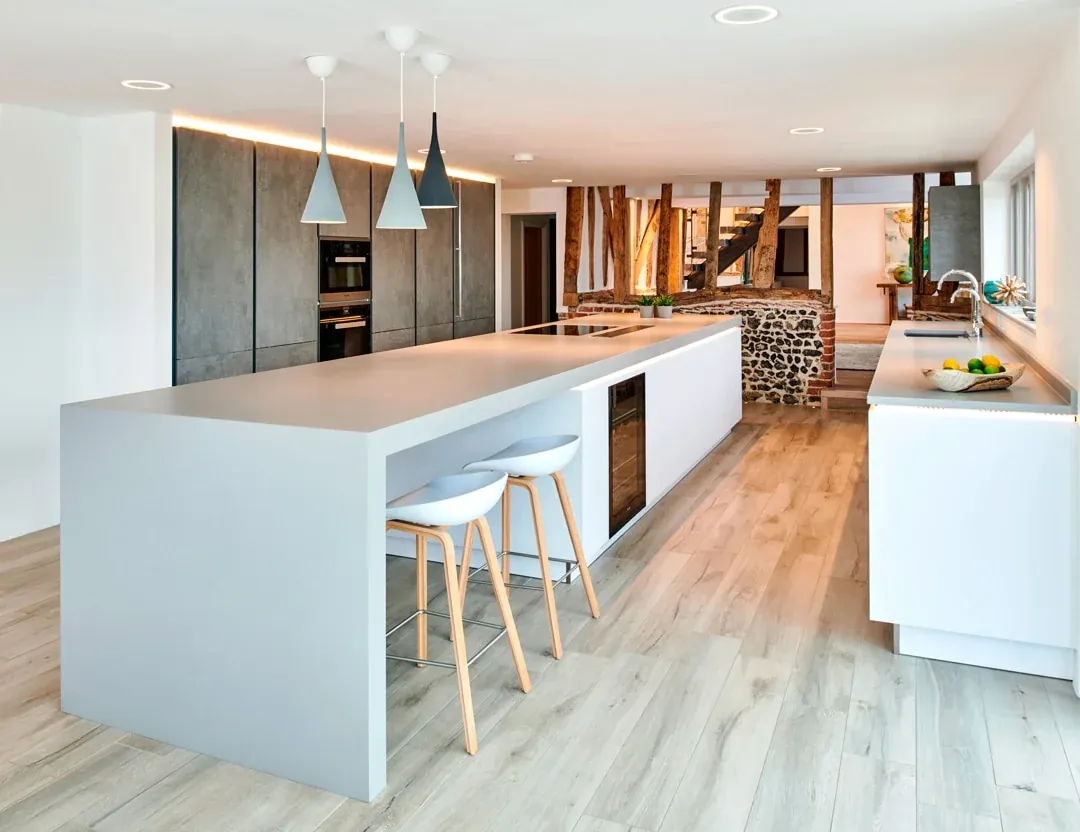 Long Silestone island in a modern kitchen with concrete-style cabinetry
